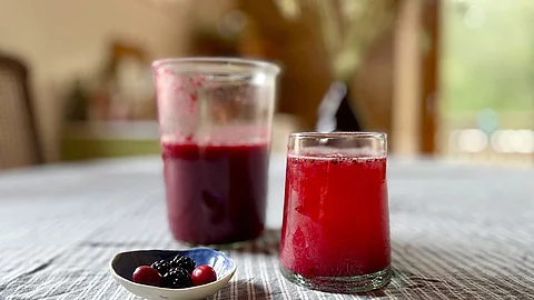 Fruchtoxymel aus Brombeeren und Kornelkirschen in einem Glas auf einem Tisch