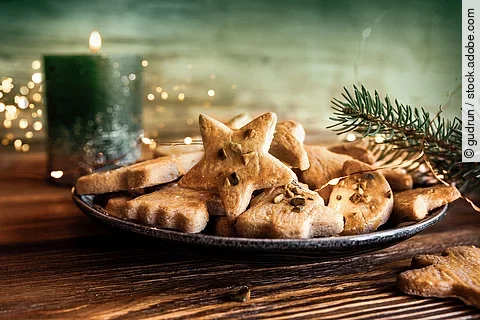 Weihnachtsplätzchen und eine brennende Kerze