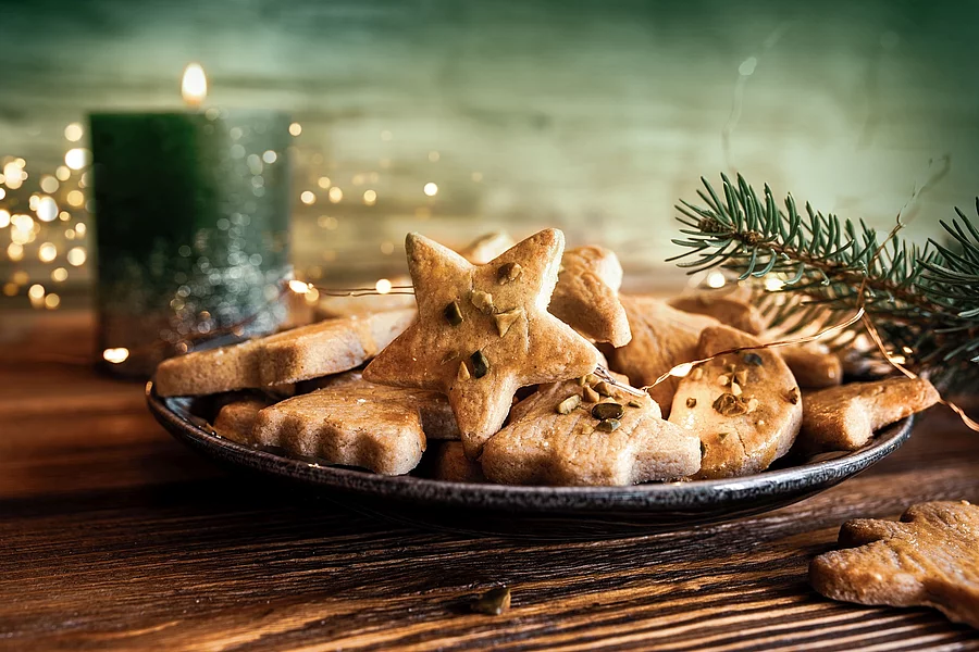 Weihnachtsplätzchen und eine brennende Kerze