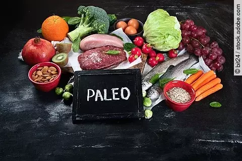Various Paleo diet products rohes Fleisch, Obst, Gemüse, Fisch - attraktiv angeordnet auf einem Schieferteller