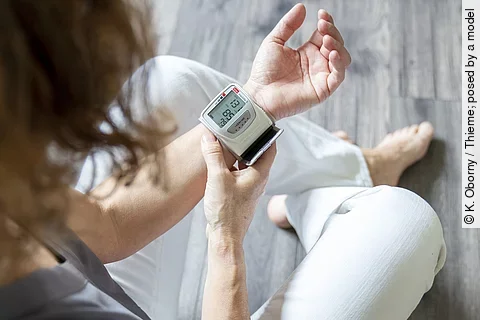 Frau misst Blutdruck am Handgelenk