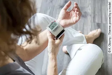 Frau misst Blutdruck am Handgelenk