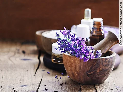Lavendelblüten in Holzschale, Braunfläschchen mit ätherischem Öl