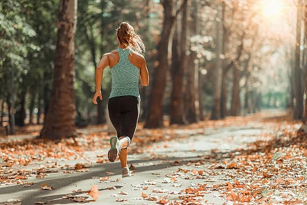 Woman Jogging Outdoors in The Fall junge Frau joggt im Wald