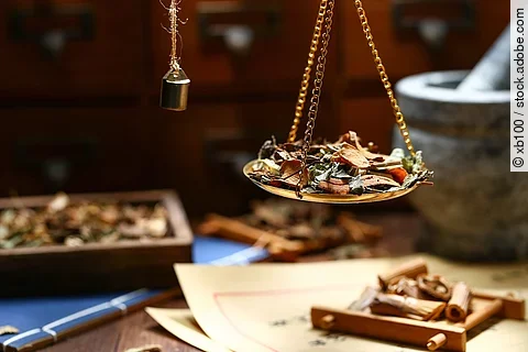 chinesische Arzneistoffe auf einer Hängewaage