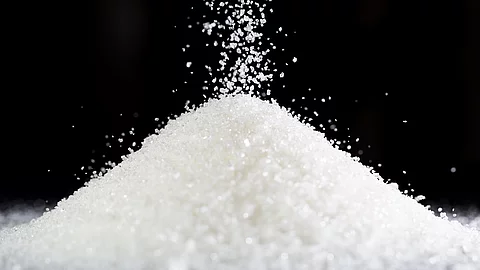 Ein Haufen Zucker auf schwarzem Hintergrund.