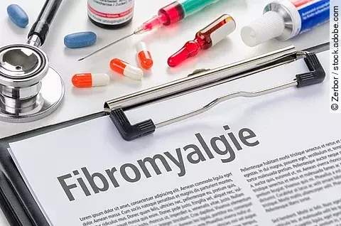 Schriftzug Fibromyalgie auf einem Blatt, welches in ein Klemmbrett gesteckt ist.