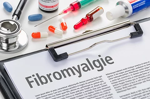 Schriftzug Fibromyalgie auf einem Blatt, welches in ein Klemmbrett gesteckt ist.