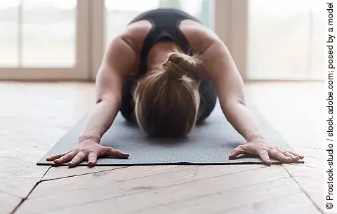 Frau auf Yogamatte, Kind-Asana
