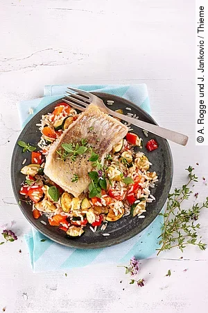 Seelachsfilet auf Gemüsereis auf einem Teller