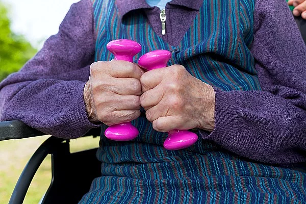 Alte Frau im Rollstuhl mit Hanteln
