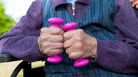 Alte Frau im Rollstuhl mit Hanteln