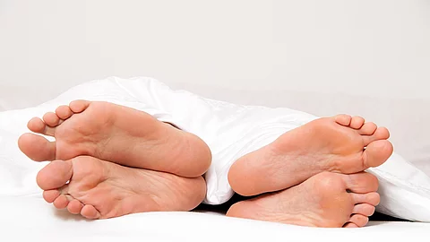Füße eines Paares im Bett. Trennung und Scheidung Dier Füße eines Paares im Bett.