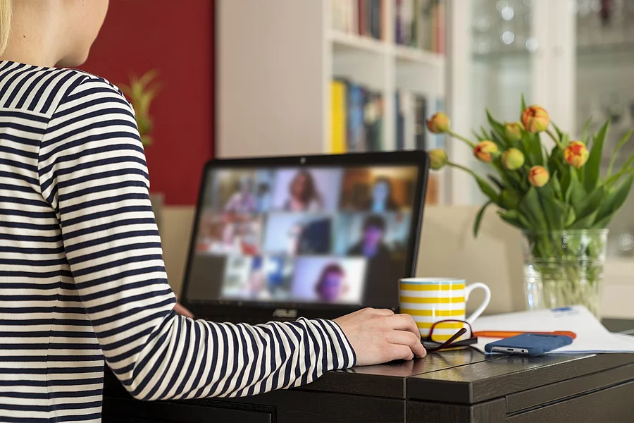 Frau sitzt im Homeoffice in Onlinemeeting