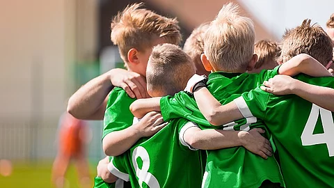 Kinder-Fußballteam. Jungs stehen in einem Kreis und umarmen sich.