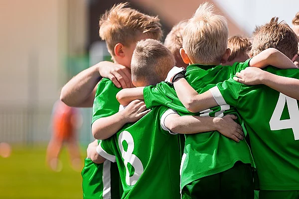 Kinder-Fußballteam. Jungs stehen in einem Kreis und umarmen sich.