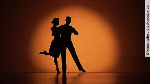 Tango tanzendes Paar auf der Bühne im Scheinwerferkegel