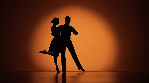 Tango tanzendes Paar auf der Bühne im Scheinwerferkegel