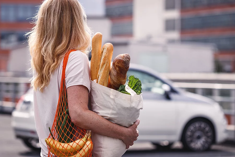Frau mit Einkaufstüten auf einem Parkplatz Frau mit Einkaufstüten auf einem Parkplatz
