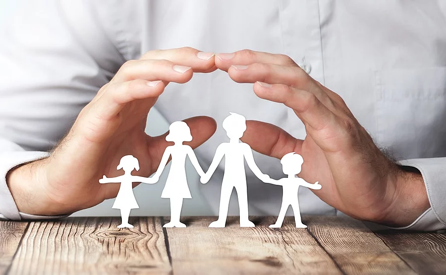 Protecting Hands Over Paper Family / Family Protection And Care Concept Schützende Hände über einer Familie aus Papier