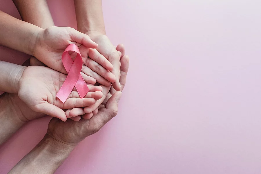 hands holding pink ribbons, Breast cancer awareness and October Pink day, world cancer day Frauenhände halten pinkfarbene Schleife; Krebs-Symbol-Schleife