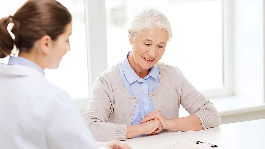 Ärztin im Gespräch mit einer Seniorin im Krankenhaus