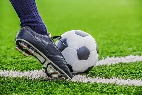 Fußball mit Fuß auf dem Fußballfeld