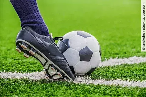 Fußball mit Fuß auf dem Fußballfeld