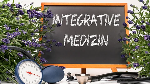 Tafel mit Aufschrift: Integrative Medizin, daneben Stethoskop und Lavendelblüten