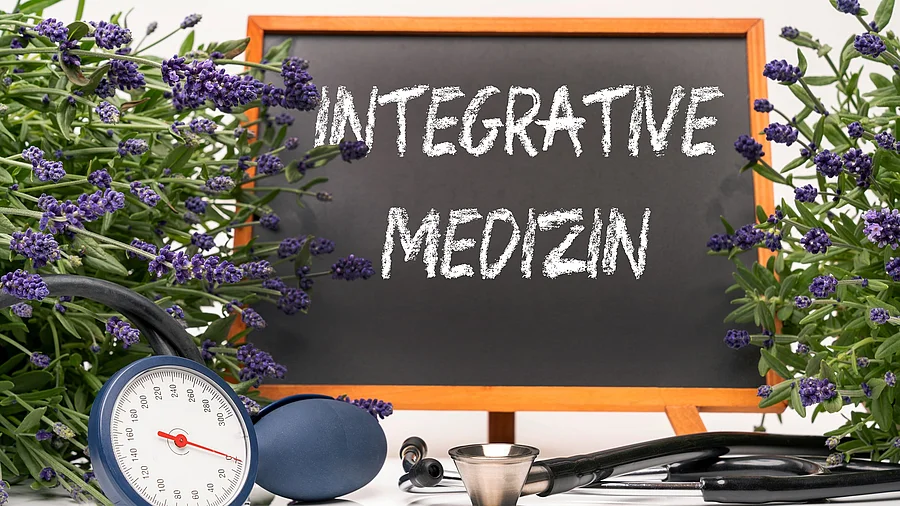 Integrative Medizin Tafel mit Aufschrift: Integrative Medizin, daneben Stethoskop und Lavendelblüten