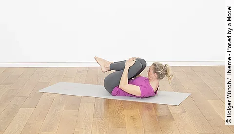 Frau auf der Matte mit angebeugten Knien