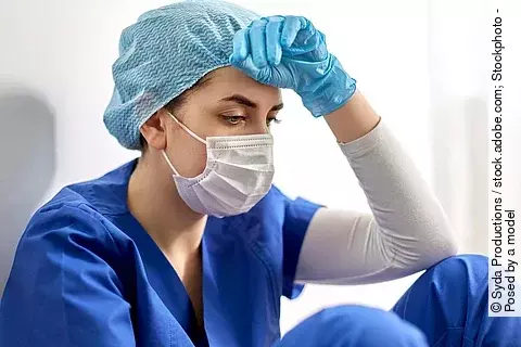 junge Ärztin mit Mundschutz in OP-Kleidung; Symbolbild psychische Belastung während der Corona-Pandemie