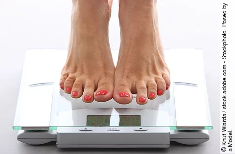 Frauenfüße auf einer Personenwaage