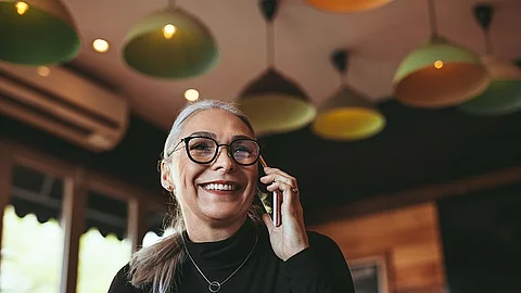 Frau telefoniert mit dem Handy in einem Cafe