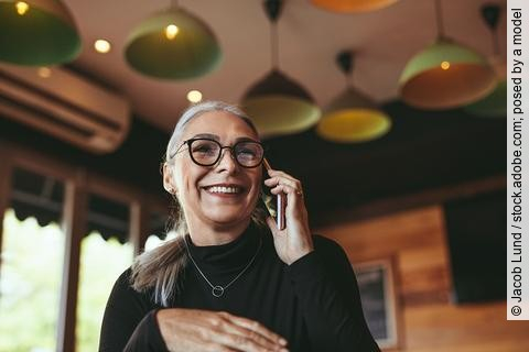 Frau telefoniert mit dem Handy in einem Cafe