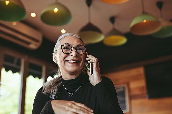 Frau telefoniert mit dem Handy in einem Cafe