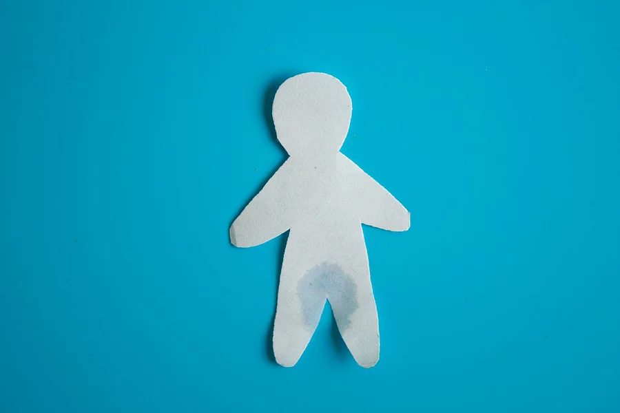 Urinary incontinence concept Nasse Papierfigur auf blauem Hintergrund