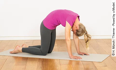 Frau auf der Matte im Vierfüßler mit rundem Rücken