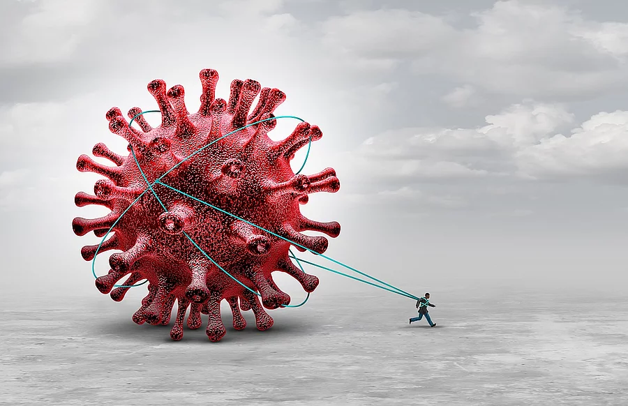 Symbolbild Long Covid: Ein Mensch zieht riesiges Coronavirus hinter sich her