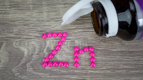 Pinke Pillen gelegt zu Zn neben Braunfläschchen Pinke Pillen gelegt zu Zn neben Braunfläschchen