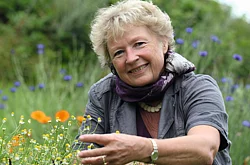 Porträtfoto: Ursel Bühring auf einer Blumenwiese