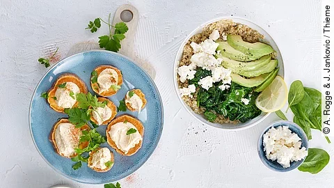 Ballaststoffreiche Speisen auf Tellern: Hummus, Süßkartoffel, Quinoa mit Spinat, Melone und Schafskäse Ballaststoffreiche Speisen auf Tellern: Hummus, Süßkartoffel, Quinoa mit Spinat, Melone und Schafskäse
