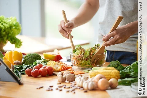 Frau bereitet Salat zu