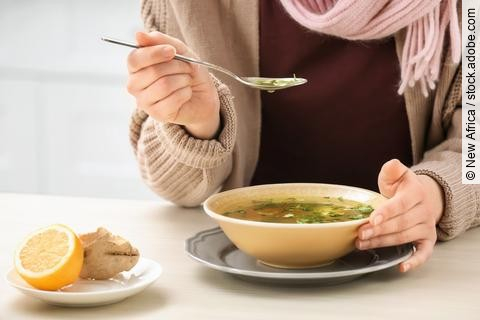Frau isst eine Suppe.