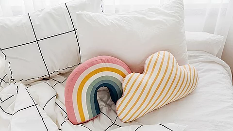 White bedding sheets with striped blanket and bright pillow. Messy bed. Bett, weiße Bettwäsche, Nackenkissen, Kopfkissen, Decke