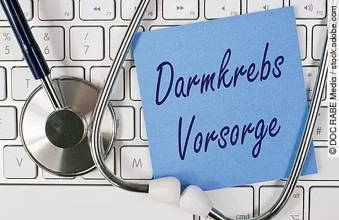 Symbolbild Darmkrebs-Vorsorge, Stethoskop, Tastatur und blauer Zettel mit Schriftzug Damkrebs Vorsorge
