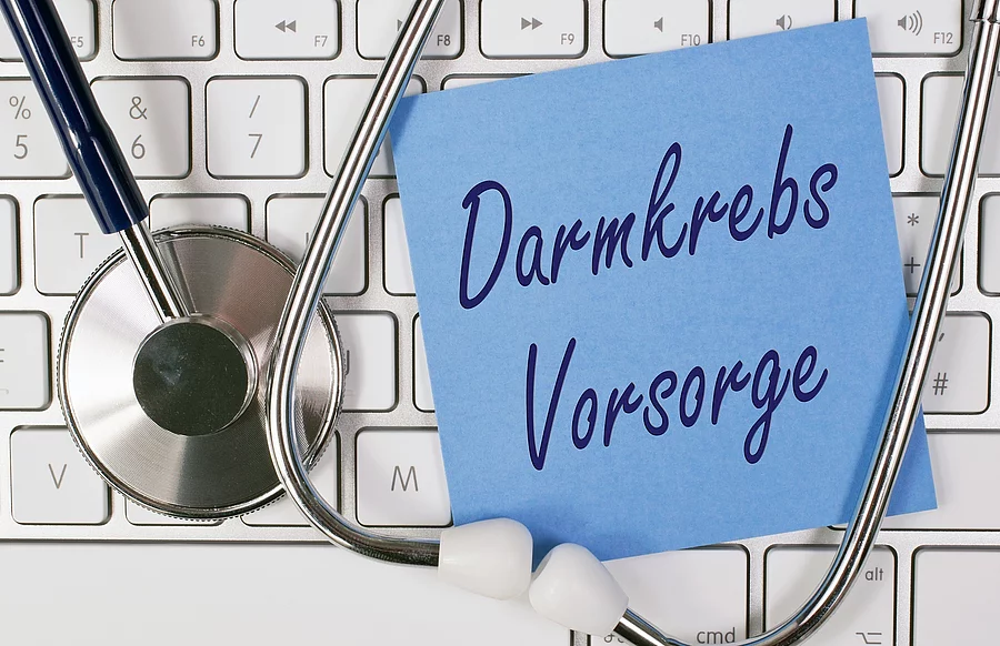 Symbolbild Darmkrebs-Vorsorge, Stethoskop, Tastatur und blauer Zettel mit Schriftzug Damkrebs Vorsorge