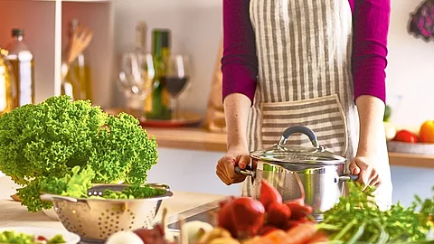 Frau kocht in der Küche gesundes Essen.