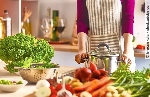 Frau kocht in der Küche gesundes Essen.