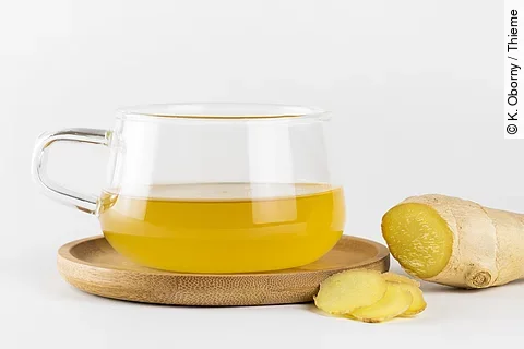 aufgeschnittener Ingwer und Teeglas mit Ingwertee